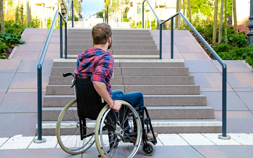 student in wheelchair in front of stairs