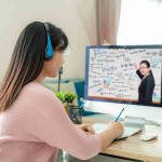 Asian woman student video conference e-learning with teacher on computer in living room at home