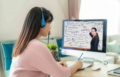 Asian woman student video conference e-learning with teacher on computer in living room at home