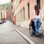 Young couple in wheelchair strolling in Heidelberg, Germany.