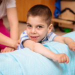 kid with cerebral palsy has musculoskeletal therapy by doing exercises