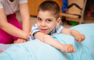 kid with cerebral palsy has musculoskeletal therapy by doing exercises