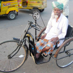 Man with a disability using a tricycle on road, Hyderabad