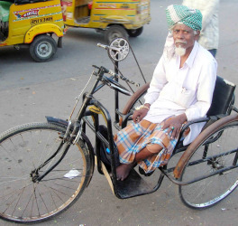 Man with a disability using a tricycle on road, Hyderabad