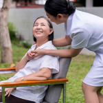 Nurse holding hands to elderly asian woman
