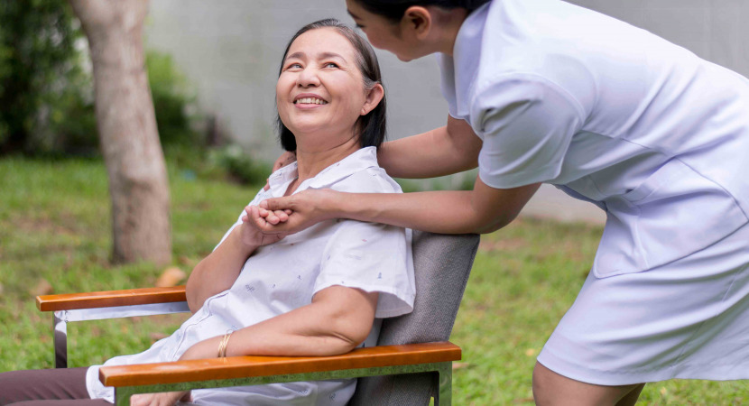 Nurse holding hands to elderly asian woman