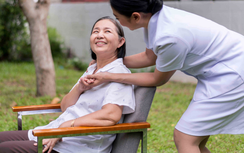 Nurse holding hands to elderly asian woman