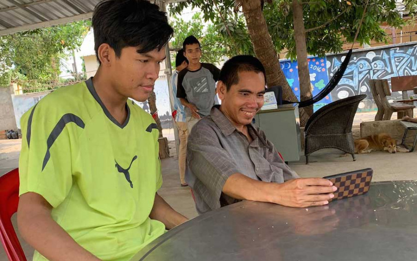 Together with his friend Sokkhai, left, ChoubKosal, who was born deaf, views a Covid-19 public service video at the Maryknoll Deaf Development Program in Phnom Penh, Cambodia.