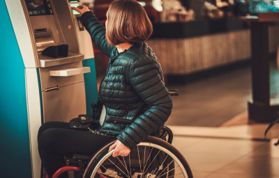 woman in wheelchair using ATM