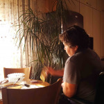 a woman in wheelchair eating at home