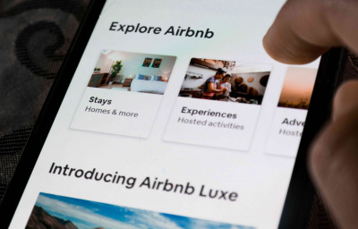 A user using the Airbnb app on a smartphone - exploring travel destinations