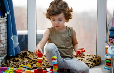 Little autistic boy playing with cubes at home