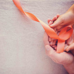 Hands holding orange ribbons multiple sclerosis awareness