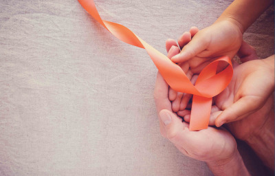 Hands holding orange ribbons multiple sclerosis awareness