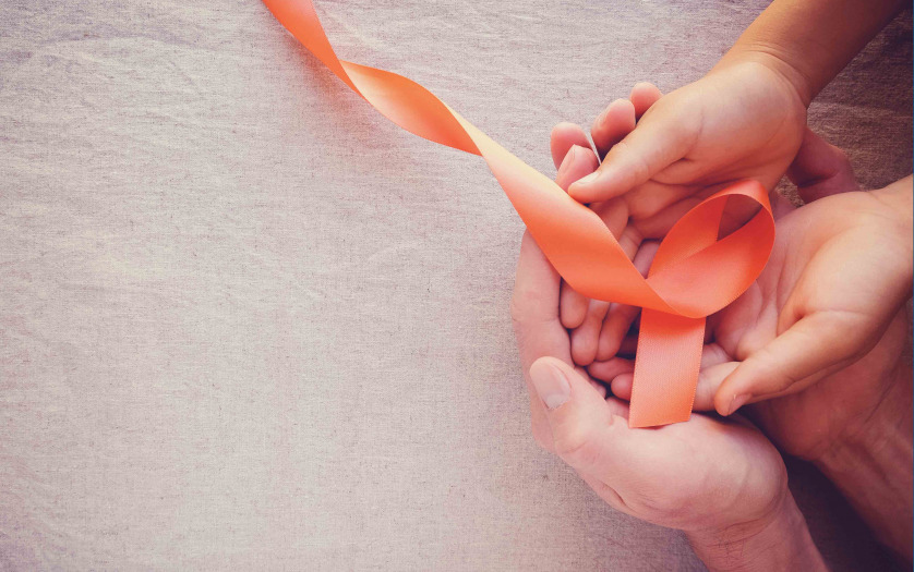 Hands holding orange ribbons multiple sclerosis awareness