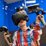 boy in virtual reality headset playing videogame