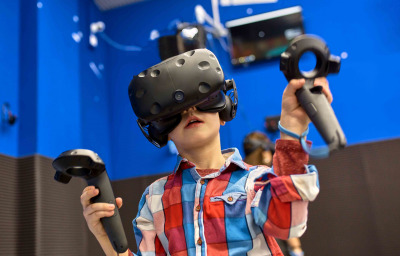 boy in virtual reality headset playing videogame