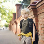stressed little boy with backpack