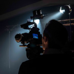 A man watches the screen of the camera on a film set