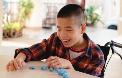 child in wheelchair molding clay, Fun and entertaining activity for training small and large muscles