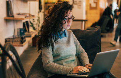 Woman with glasses using laptop in modern interior