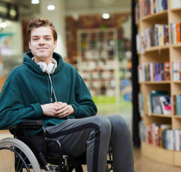 student in wheelchair in library