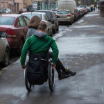 a man in a wheelchair with girl on the street