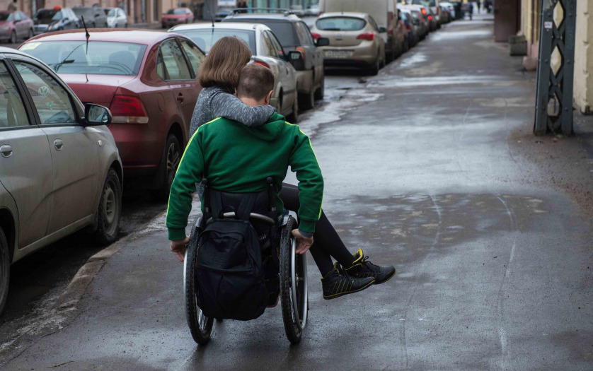 a man in a wheelchair with girl on the street