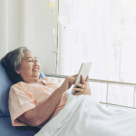 Elderly woman patients in hospital bed patients using tablet to communicate