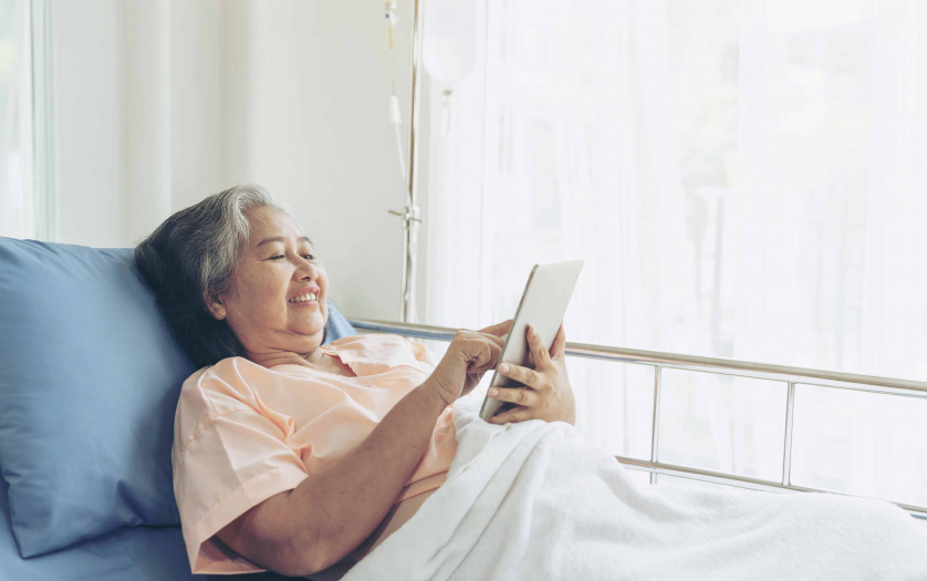 Elderly woman patients in hospital bed patients using tablet to communicate