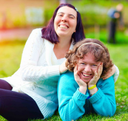 Portrait of happy women with disability having fun on spring lawn