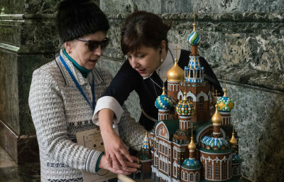 a blind woman in the state museum. The guide shows the blind woman exhibits.