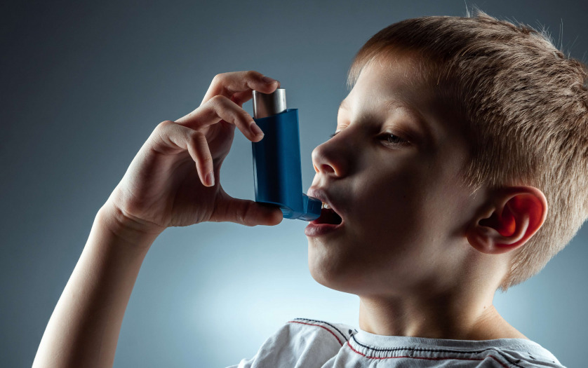Portrait of a boy using an asthma inhaler