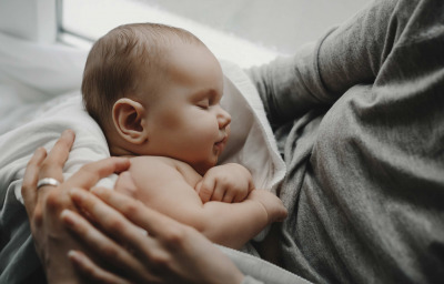 Charming newborn boy sleeps on mother's arms