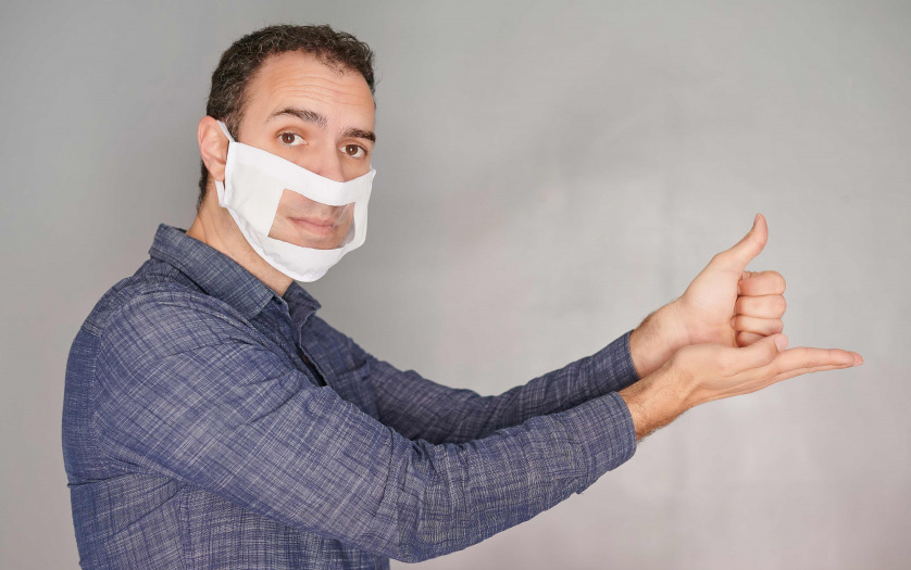 Sign language interpreter wears transparent face mask