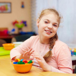 girl with disability develops the fine motor skills at rehabilitation center