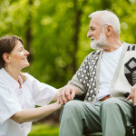 Nurse and patient in the garden of modern senior home with daily care