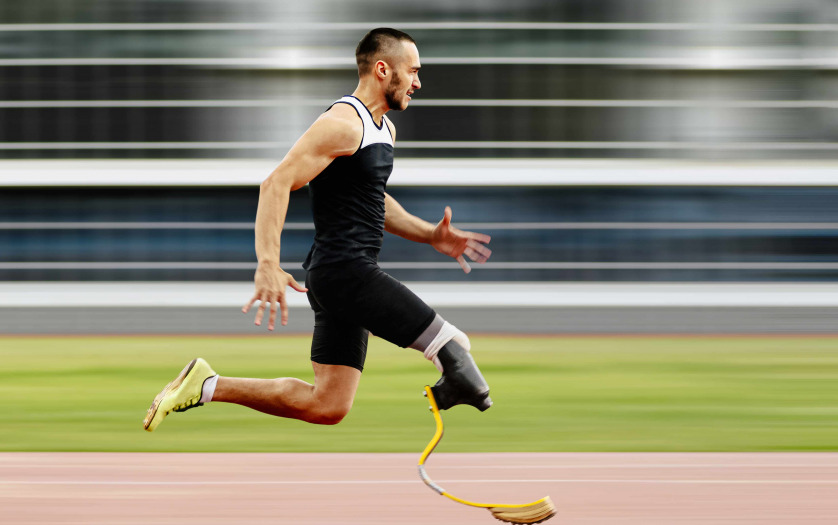 athlete amputee leg running with prosthetic on background of motion blur