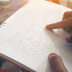 Close-up of fingers reading braille