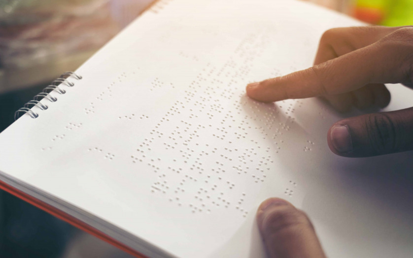 Close-up of fingers reading braille