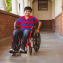 Boy sitting in wheelchair in school corridor