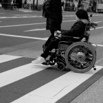 woman in wheelchair crossing the road