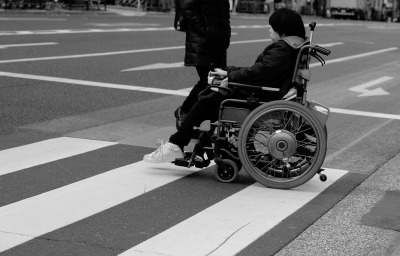 woman in wheelchair crossing the road