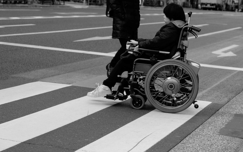 woman in wheelchair crossing the road