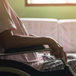 woman in wheelchair looking out the window