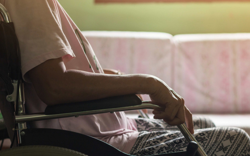 woman in wheelchair looking out the window