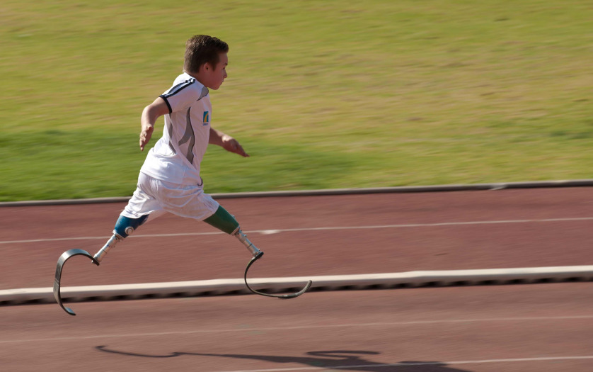 young disabled athlete running 100m sprint