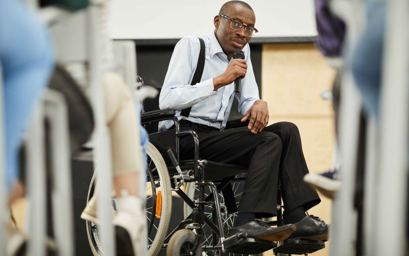 speaker in wheelchair speaking at conference