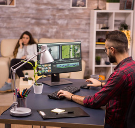 Creative videographer editing a movie on computer from home