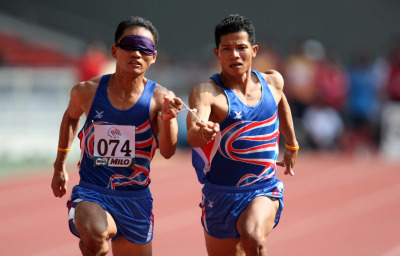 Thailand's blind athlete Kitsana Jorchuy runs with a guide at the track and field event of the fifth ASEAN Para Games on August 15, 2009 in Kuala Lumpur.